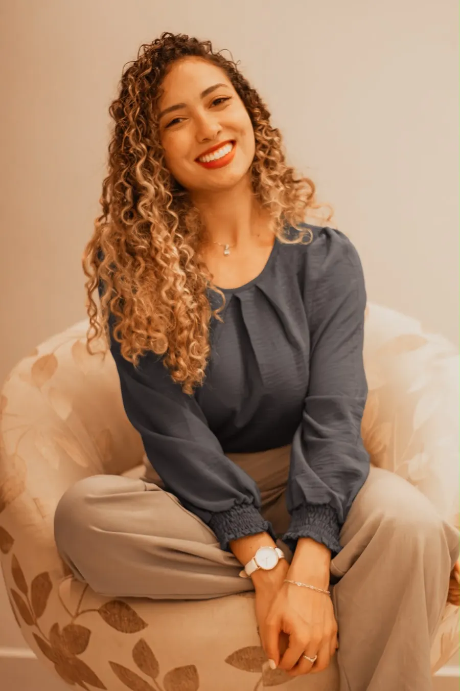 Isabella Lacerda sentada em uma poltrona, sorrindo