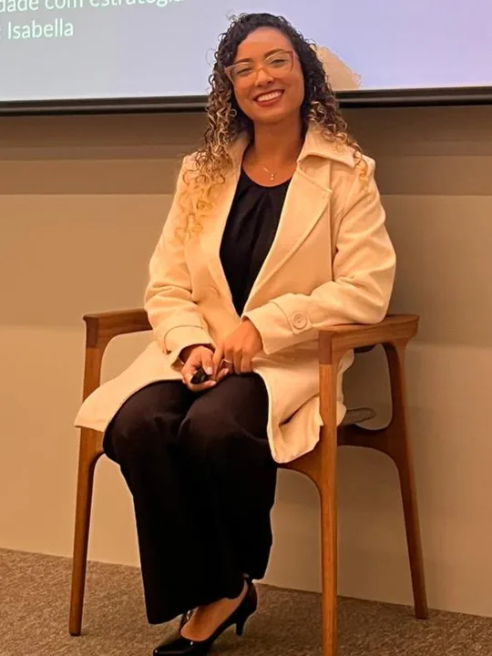 Isabella Lacerda sorrindo no palco, antes do treinamento Produtividade com estratégia